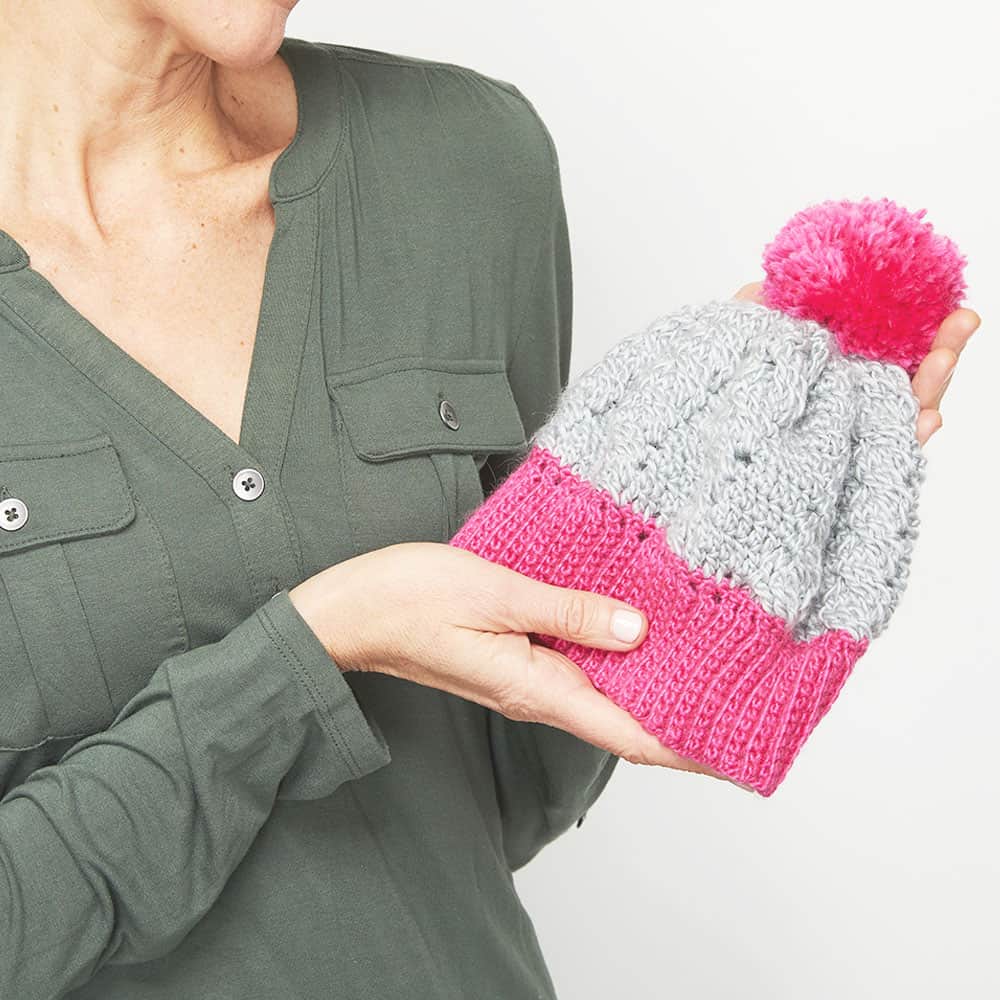This crochet hat is beautiful and simple. You can personalize the free crochet pattern with different colors and how many cables you add in. #CrochetHatPattern #CrochetPattern #CrochetCableStitch #CrochetAddict
