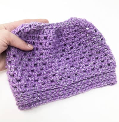 Easy Peasy Messy Bun Crochet Hat - These 26 crochet winter hat patterns are perfect to create a winter hat accessory that you love and can rely on. #crochetwinterhat #crochetpatterns #crochethatpatterns