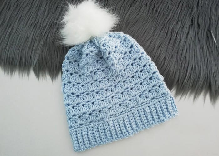 Girls Winter Pompom Hat - These 26 crochet winter hat patterns are perfect to create a winter hat accessory that you love and can rely on. #crochetwinterhat #crochetpatterns #crochethatpatterns