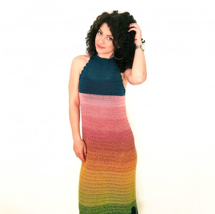 curly-haired woman wearing a striped sleeveless summer crochet dress