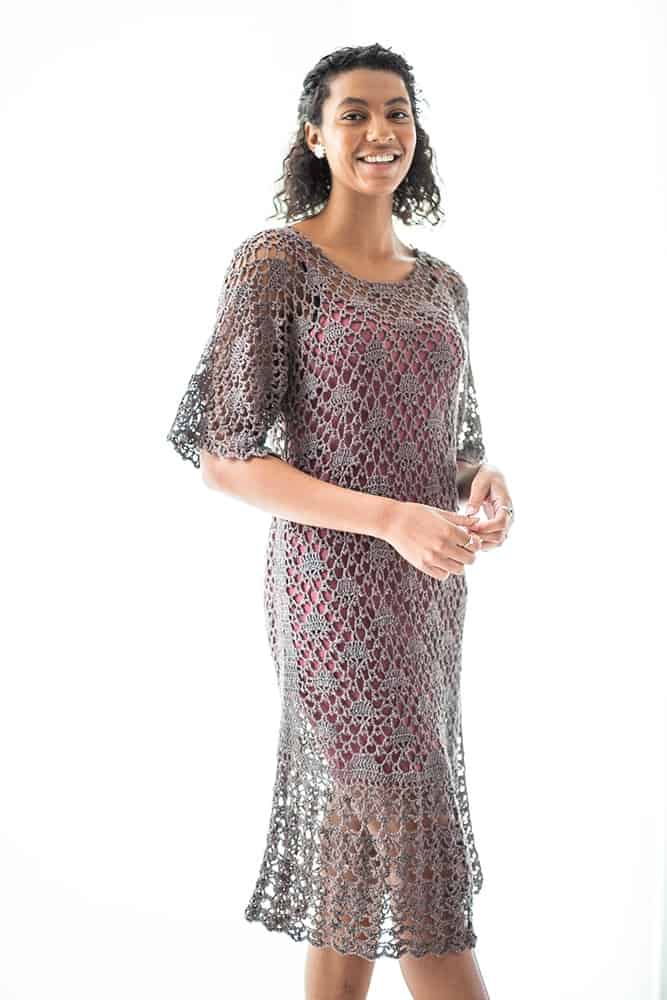 curly haired woman wearing a lacy crochet dress