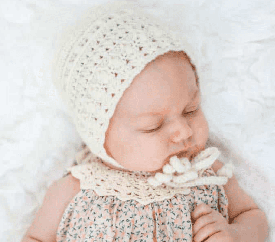 A baby wearing a Classic Crochet Baby Bonnet 