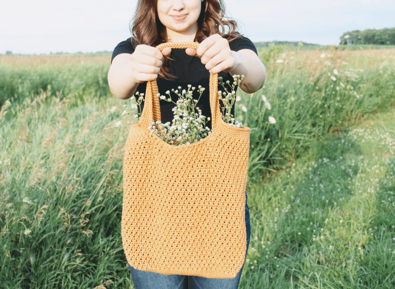 A woman holding the Summer Harvest Crochet Market Bag